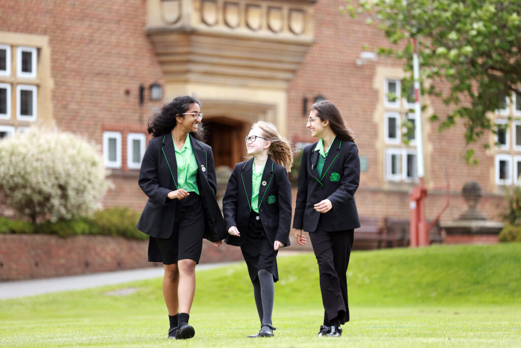 a picture of three students walking laughing